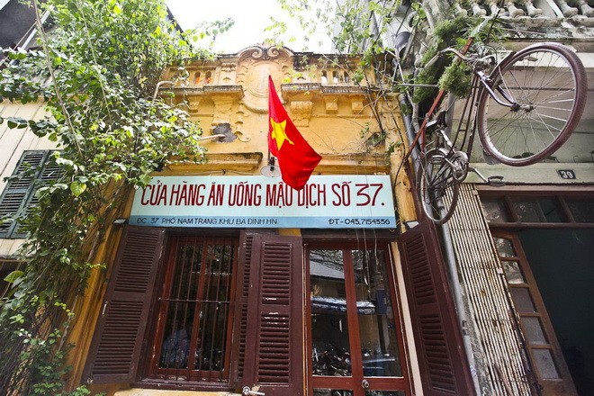 Một quốc kỳ, một chiếc xe đạp Thống nhất và một tấm biển ghi tên "Cửa hàng ăn uống mậu dịch số 37" - Ảnh: Nguyễn Khánh